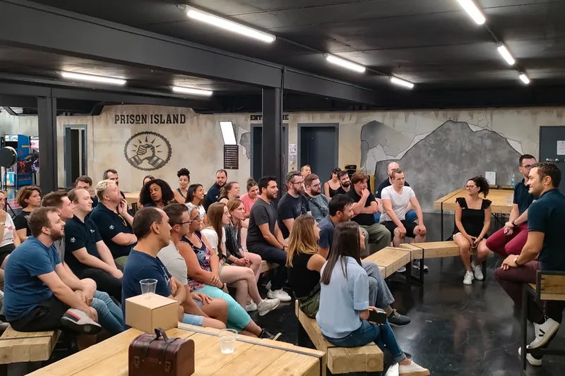 Um grupo de colegas sentados em bancos ouve o briefing antes do jogo