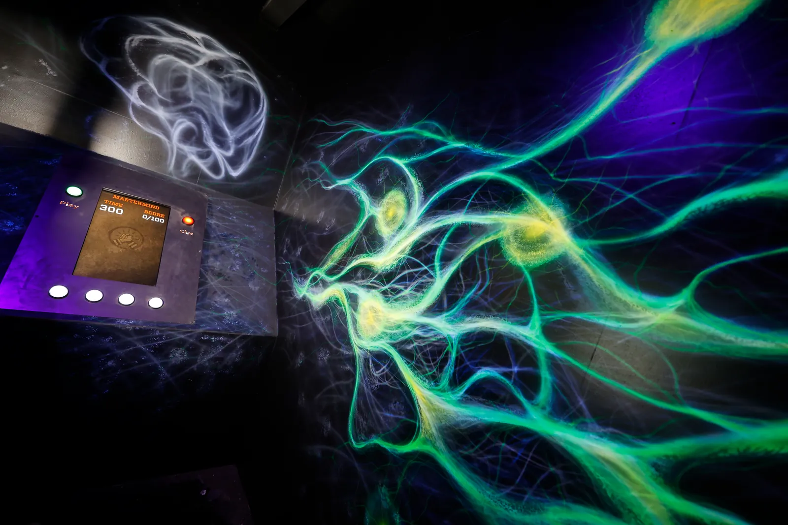 Uma medusa luminosa pintada numa parede escura, ao lado de um painel de comandos